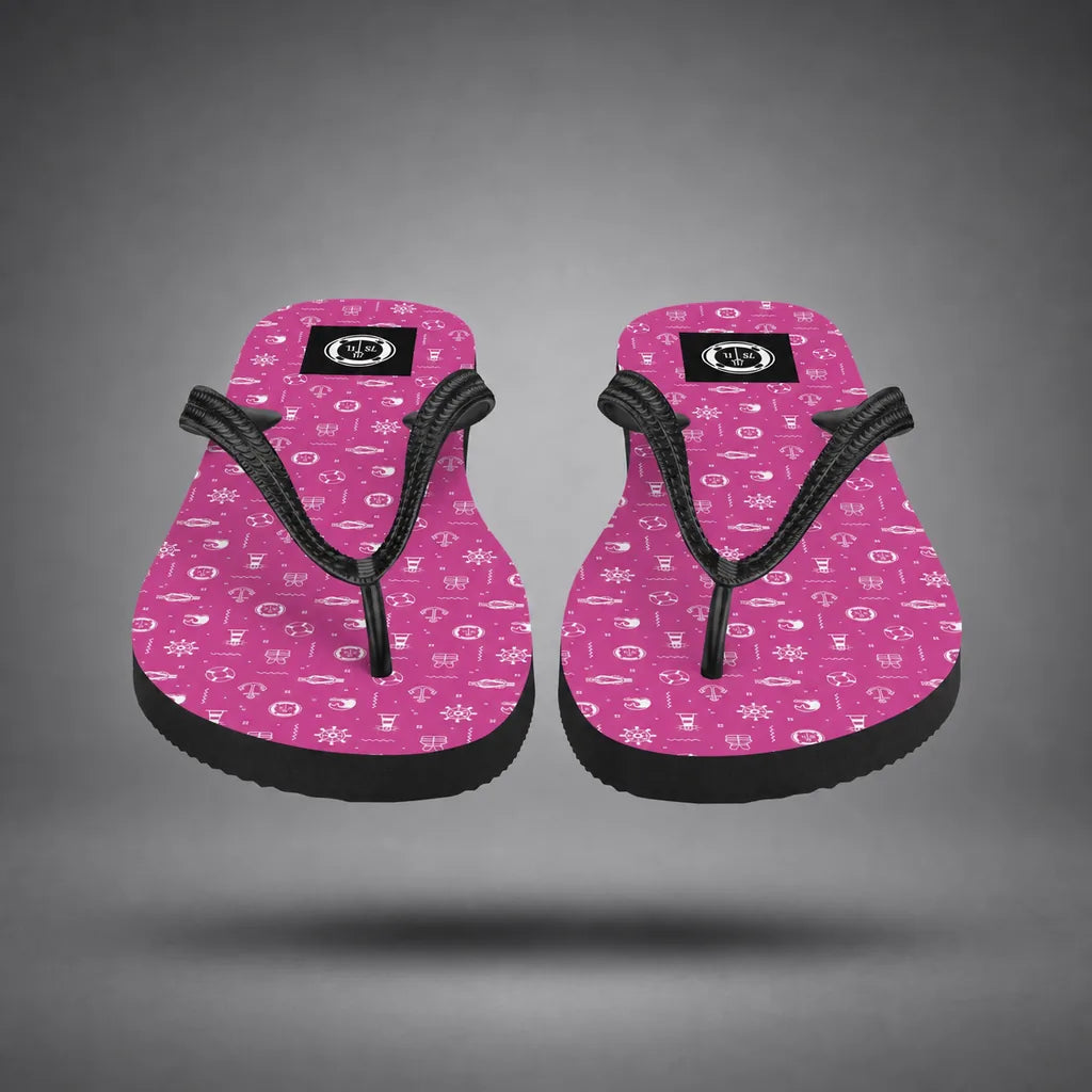 Detail view of pink Ocean Explorer flip-flops with white maritime pattern, floating above a grey studio floor with a soft shadow.