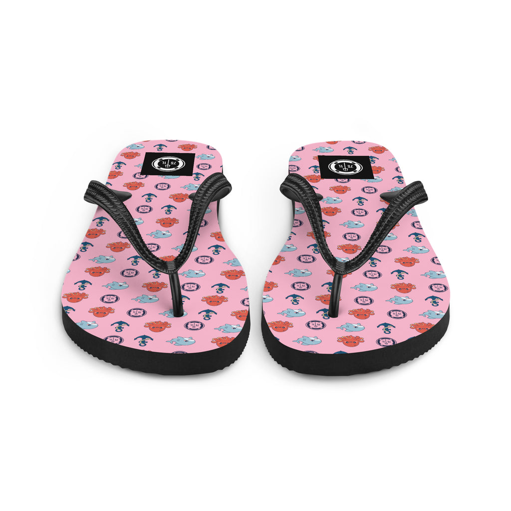 Pair of pink flip-flops with black straps nautical pattern on a white background