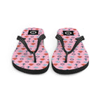 Pair of pink flip-flops with black straps nautical pattern on a white background