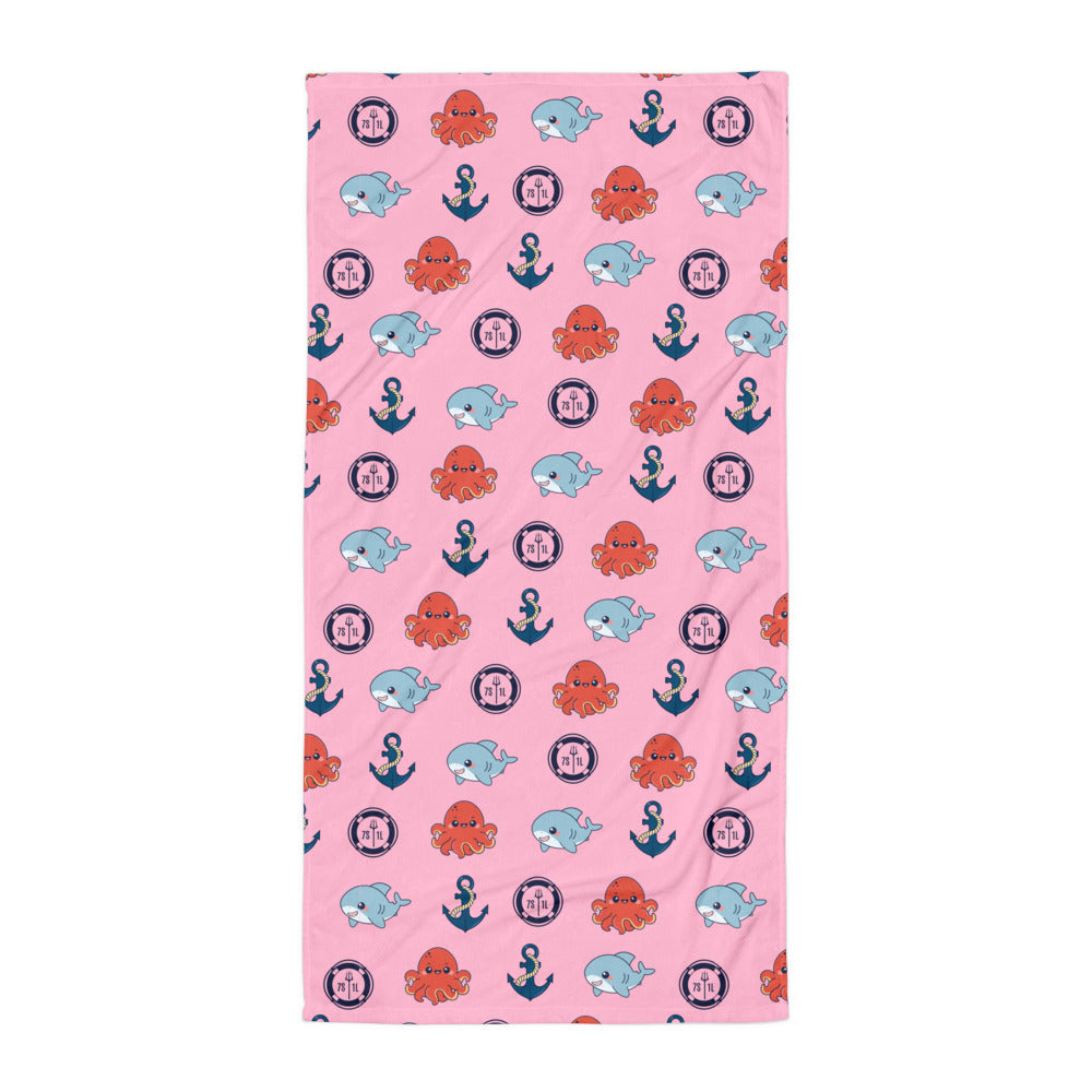 Pink towel with nautical pattern featuring octopuses, shark, and anchors on a white background