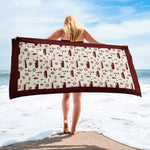 Person holding a beach towel with a pattern on a beach from shore leave