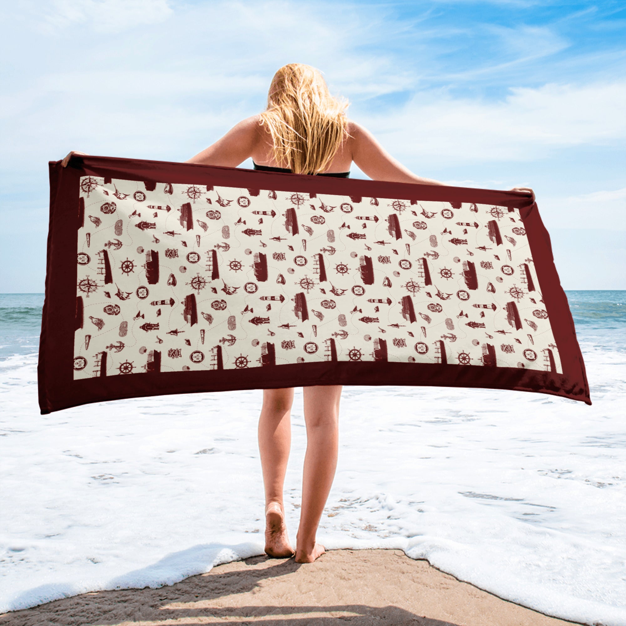 Person holding a beach towel with a pattern on a beach from shore leave