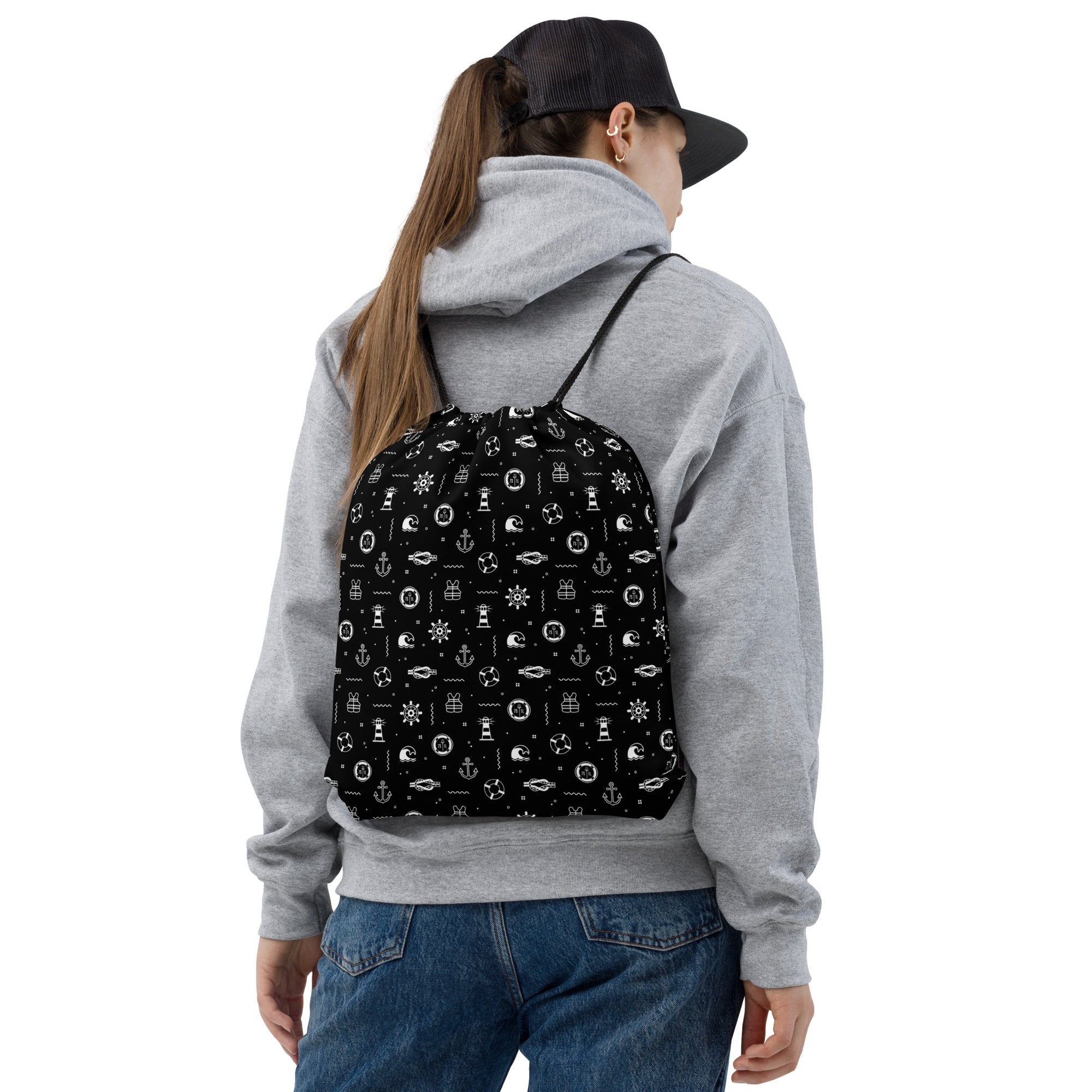 Person wearing  a black daypack featuring white nautical patterns on a white background