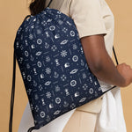 Navy drawstring bag with maritime pattern worn by a person on a beige background