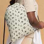 Person wearing a drawstring bag with nautical pattern on a beige background