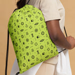 Green drawstring bag with black nautical patterns held by a person 