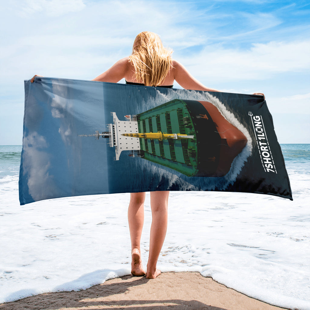 Crew member holding a beach towel with a bulk carriere design on a beach