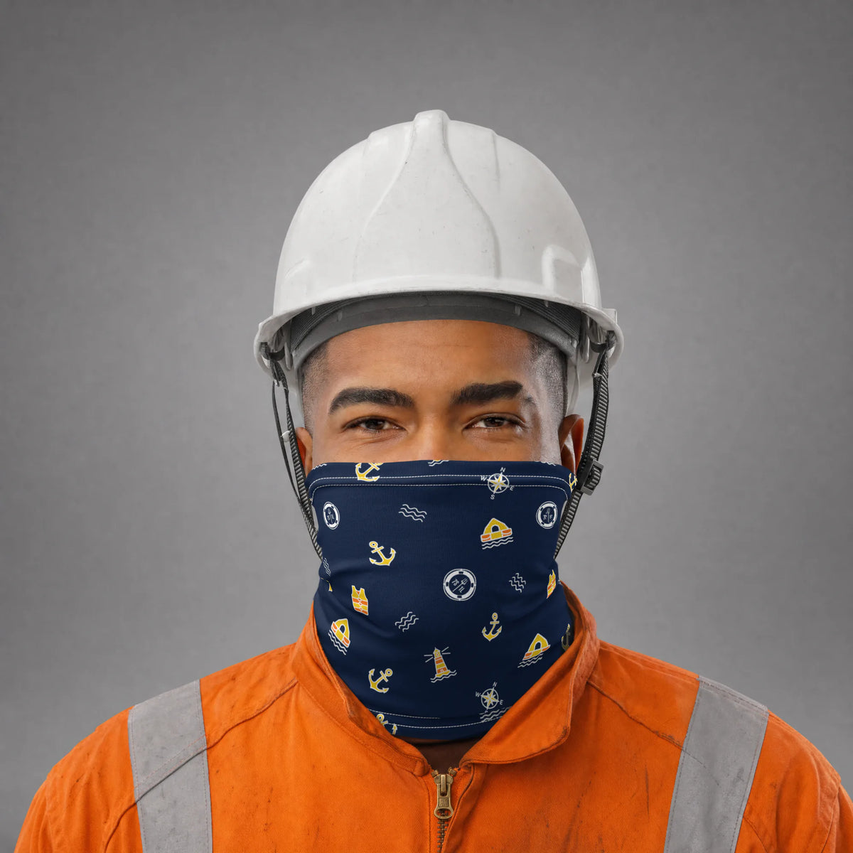 Seafarer in an orange coverall and white hard hat wearing the Bosun Ship neck gaiter over nose and mouth