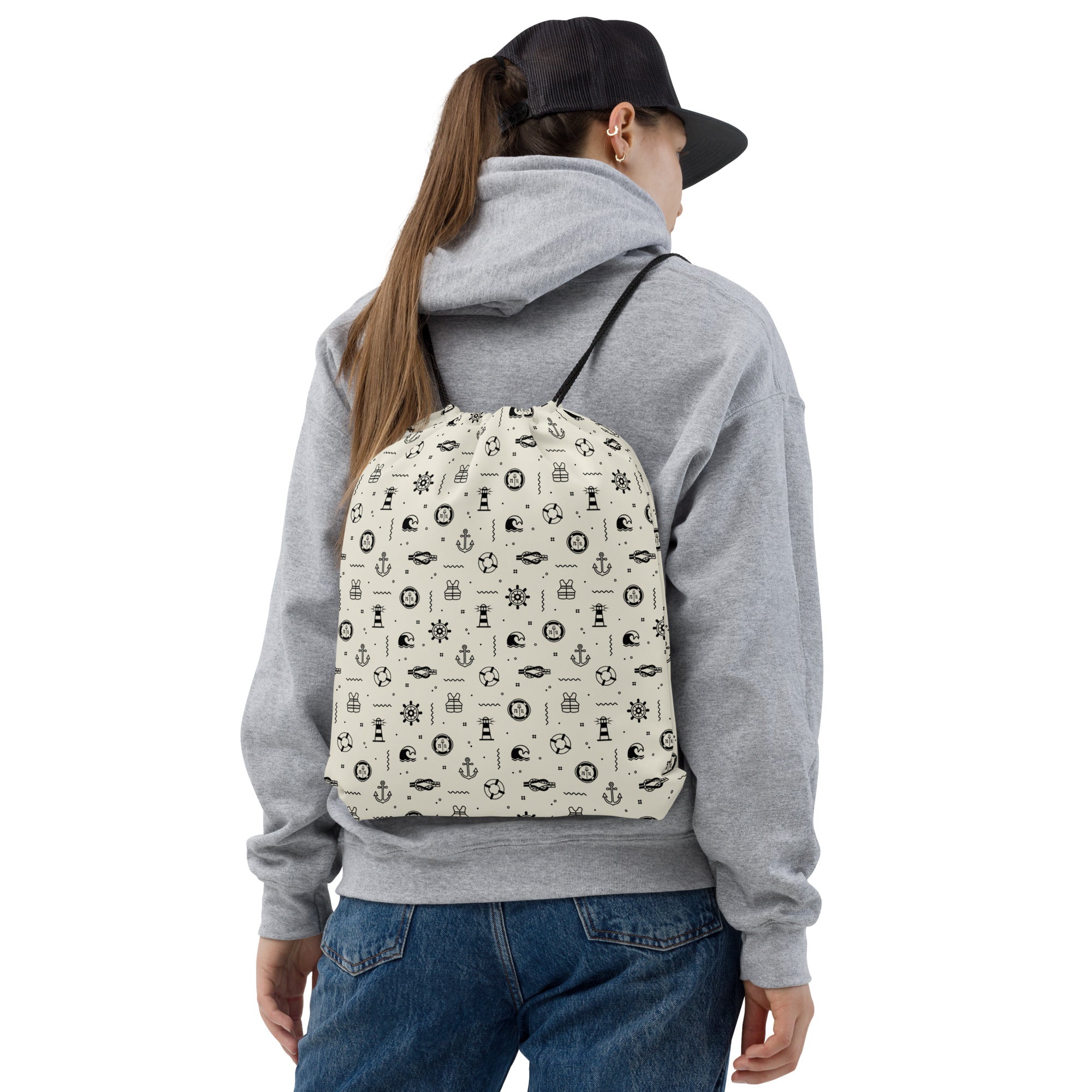 Person wearing a gray hoodie and black cap with a maritime patterned crusie ship day pack for shore leave