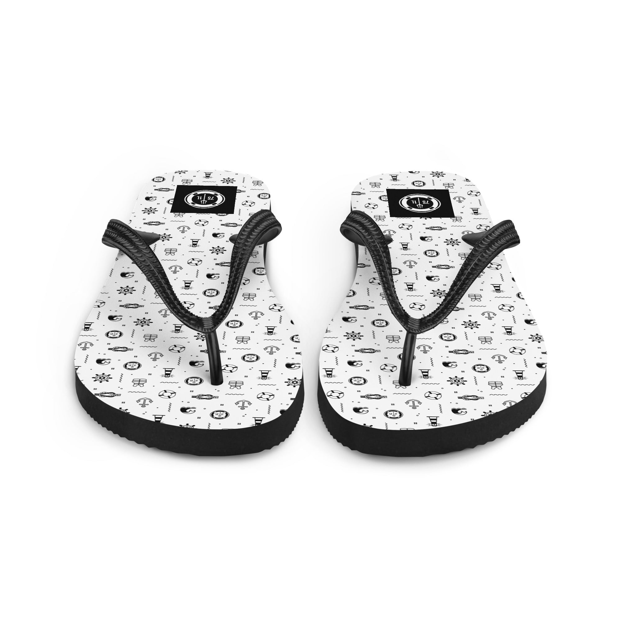 Pair of flip-flops with black maritime pattern on a beach