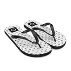 Pair of flip-flops with black maritime pattern on a beach