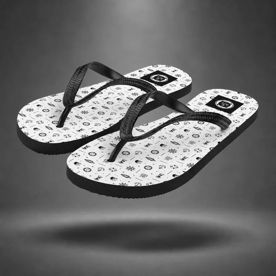 Pair of white Marine Life flip-flops with black marine life pattern, floating above a grey studio floor with a soft shadow.