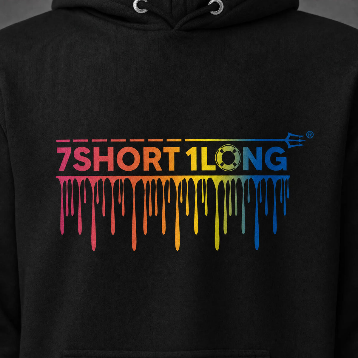 Close view of the rainbow drip wordmark on the black One Ocean hoodie, the dashed line and trident running above the letters.