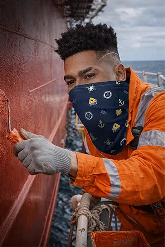 A dack hand is painting the sip and is wearing a neck gaitor for protection