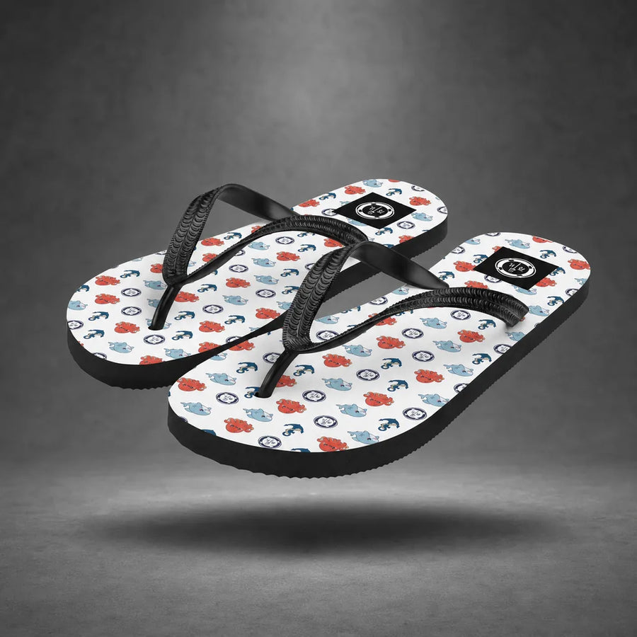 Pair of white Sea Life Anchor flip-flops with colorful sea life and anchor pattern, floating above a grey studio floor with a soft shadow.