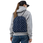 Person wearing a gray hoodie and blue jeans with a navy Nautical Kids PE Bag Maritime Sports Drawstring